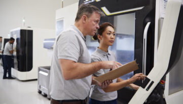 closeup of worker in safety gear setting up manufacturing equipment