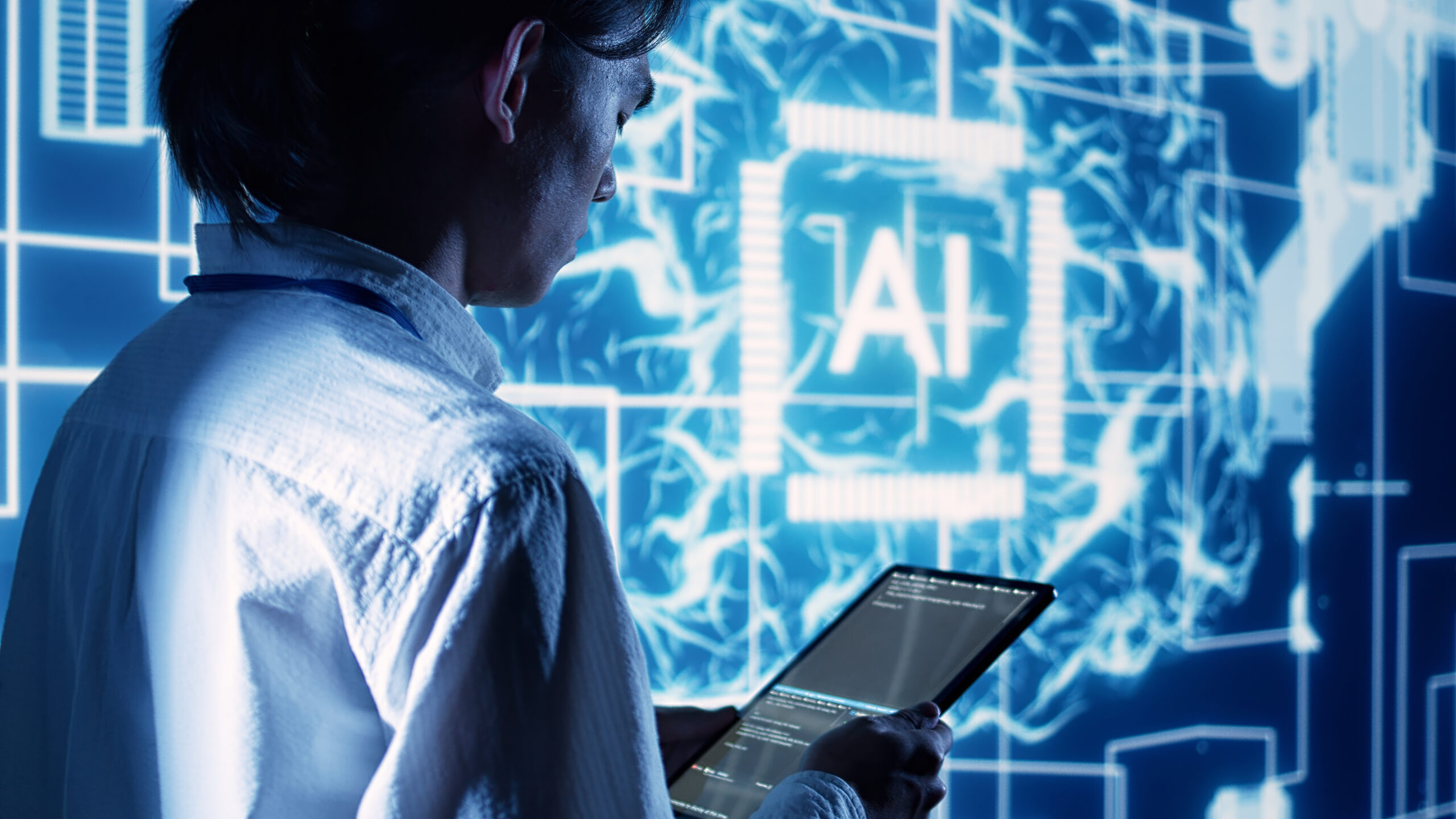 Supervisor overseeing programming scripts on tablet, developing AI machine learning tools