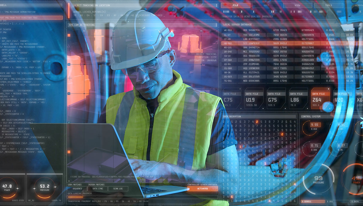Worker on a laptop working on cybersecurity for manufacturing systems