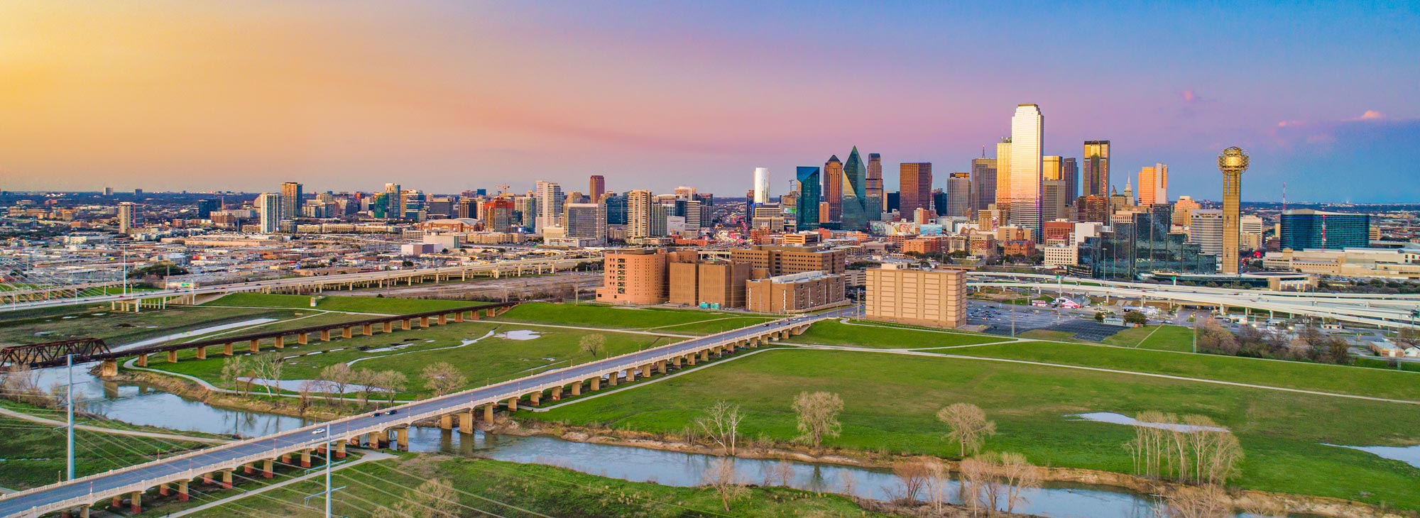 A panoramic view of downtown Dallas, Texas at sunset.