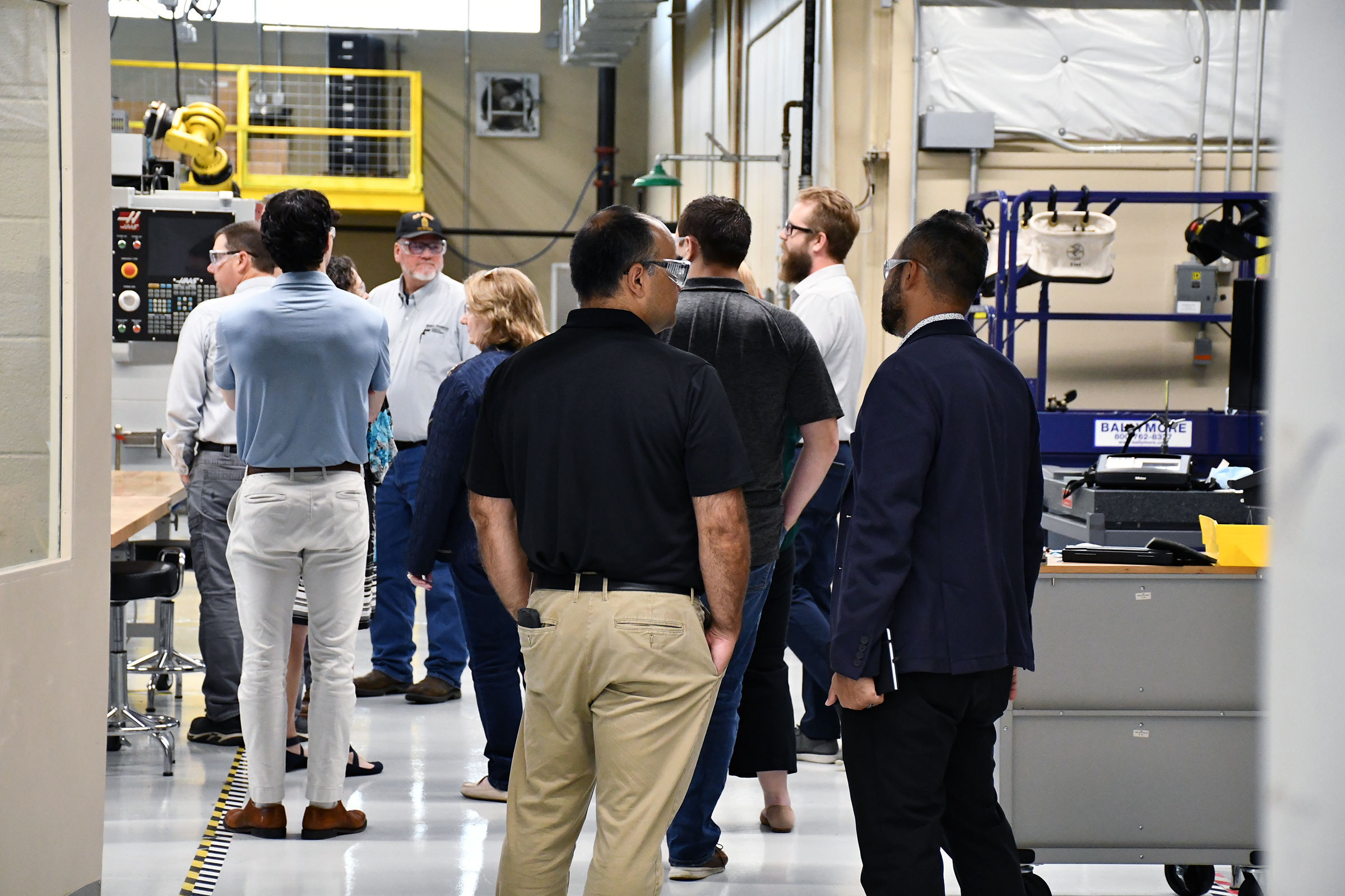 View from behind a group of individuals discussing topics at a hands-on demonstration.